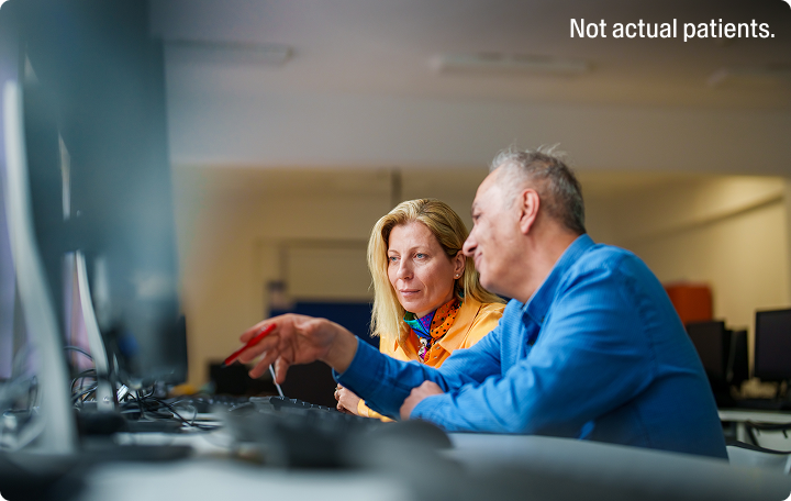 A man and woman looking at a computer